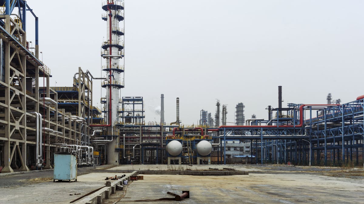 Industrial refinery with complex pipelines and steel structures at dusk